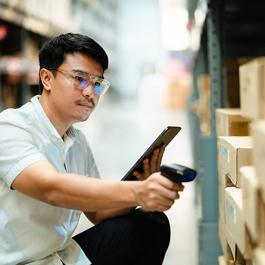 Technician in a stockroom scanning inventory levels