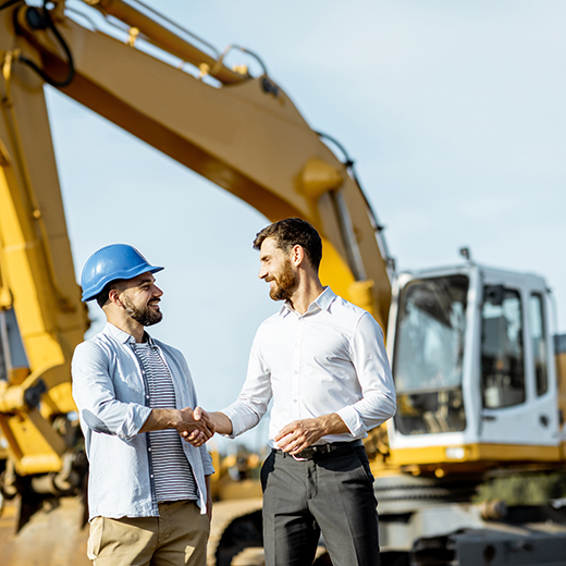 Vendor delivering heavy equipment purchase and shaking hands